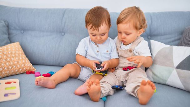 Дети сидят на диване, играют с игрушками дома
 - Фото, изображение
