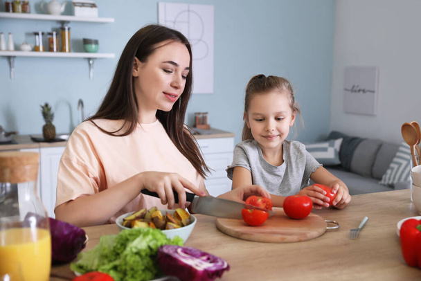 Mother with daughter cooking together in kitchen - Photo, Image