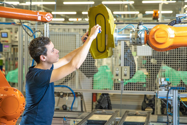 smantellamento dei bracci robotici in fabbrica quando si trasferisce la produzione in un altro paese
 - Foto, immagini
