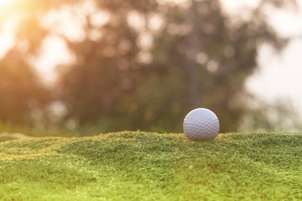 Boule de golf est sur une pelouse verte dans un beau terrain de golf avec soleil matinal.Prêt pour le golf dans le premier cours.Sports que les gens du monde entier jouent pendant les vacances pour la santé. - Photo, image