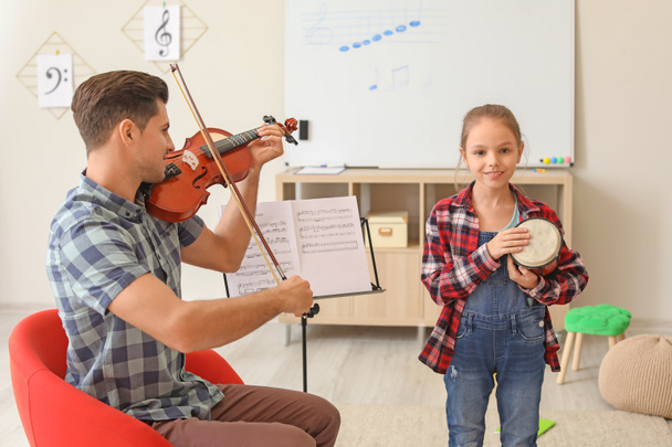 Profesor dando clases de música en la escuela
 - Foto, imagen