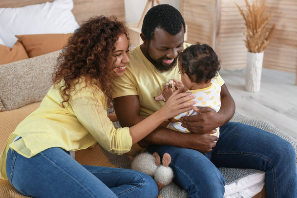 Gelukkig Afro-Amerikaanse ouders met schattige baby thuis - Foto, afbeelding