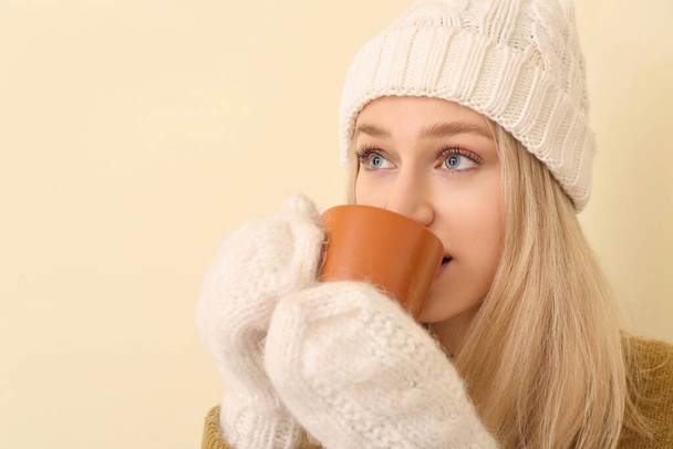 Schöne junge Frau mit Tee auf farbigem Hintergrund - Foto, Bild