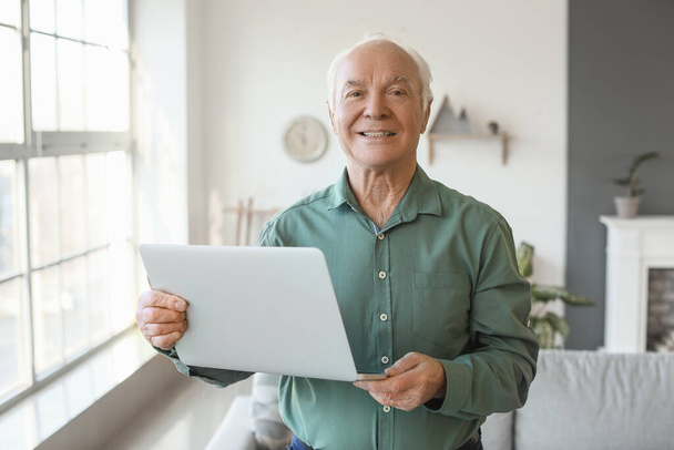 Evde dizüstü bilgisayarı olan yaşlı bir adam - Fotoğraf, Görsel