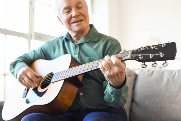 Starší muž hraje doma na kytaru - Fotografie, Obrázek