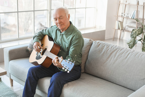 Elderly man playing guitar at home - Φωτογραφία, εικόνα