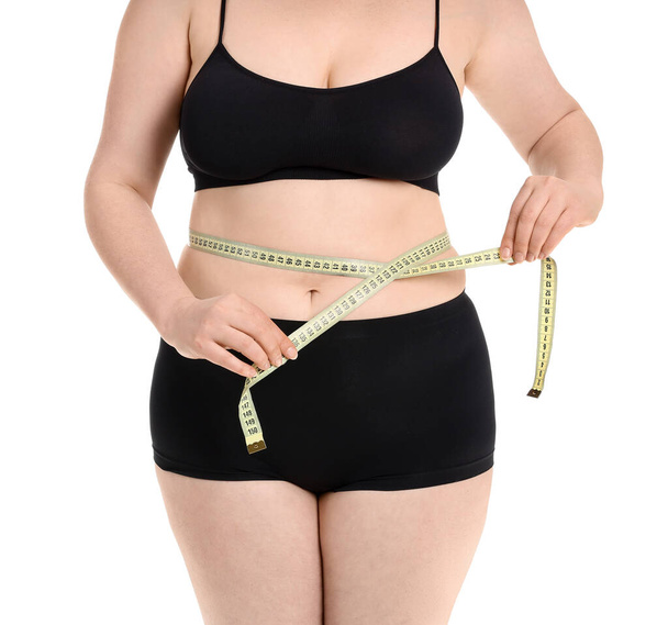 Übergewichtige Frau mit Maßband auf weißem Hintergrund. Konzept zur Gewichtsreduktion - Foto, Bild