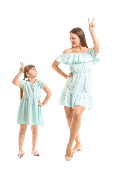 Glückliche Mutter und ihre kleine Tochter tanzen vor weißem Hintergrund - Foto, Bild