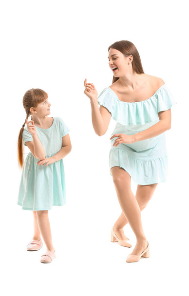 gelukkig moeder en haar dochtertje dansen tegen wit achtergrond - Foto, afbeelding
