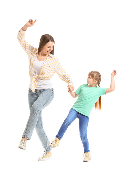 Happy mother and her little daughter dancing against white background - Fotó, kép