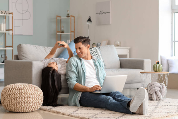 Jovem casal feliz com laptop em casa
 - Foto, Imagem