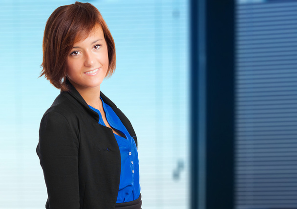 Mulher de negócios sorrindo em um ambiente de escritório
 - Foto, Imagem