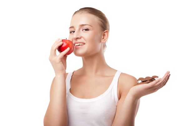 Mujer sosteniendo manzana y chocolate aislado
 - Foto, imagen