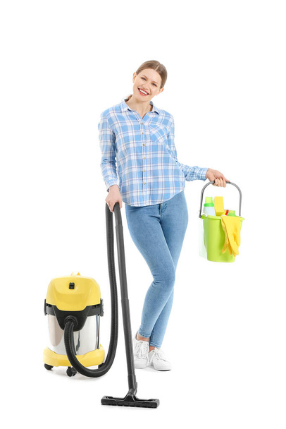 Young woman with vacuum cleaner and supplies on white background - Photo, Image