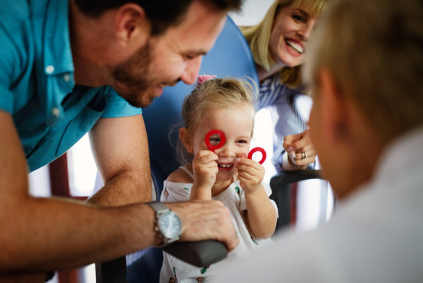 Ophthalmologist, optometrist checking child, little girl vision looking for problems and caring for eye - Foto, Imagen