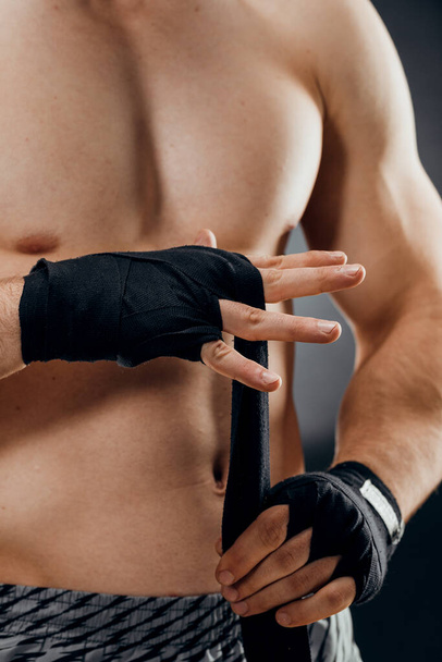 Detailní záběr mužské boxerské ruky s boxerskými obvazy. Pěsti bojovníka před zápasem nebo tréninkem v tělocvičně. Koncept sportu - Fotografie, Obrázek
