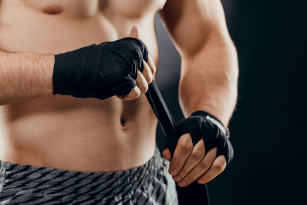 Gros plan de la main d'un boxeur masculin avec des bandages de boxe. Poings d'un combattant avant un combat ou un entraînement dans la salle de gym. Le concept de sport
 - Photo, image