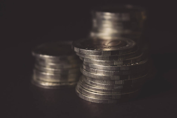 Coins stacked on each other in different positions on dark background. Money concept. Closeup. Money and saving concept. Success, wealth and poverty, poorness concept. Business Growth concept - Photo, Image
