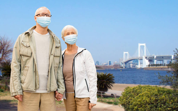 senior couple in protective medical masks in japan - Фото, зображення