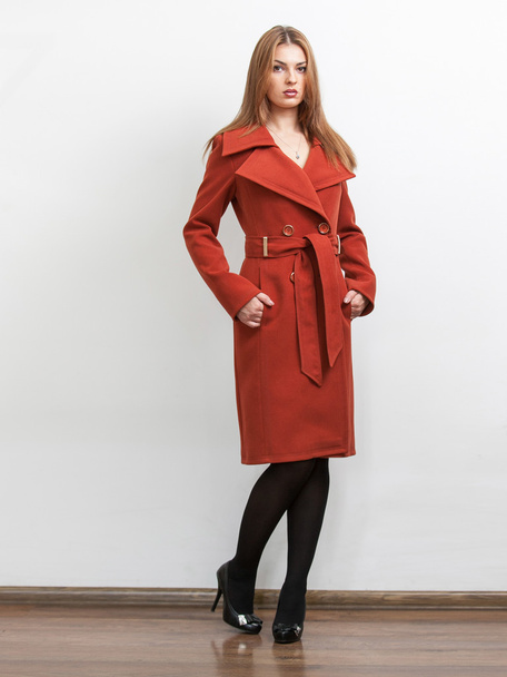 Schlankes Model trägt langen roten Mantel im Studio - Foto, Bild