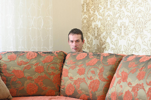 Self-Isolation during coronavirus quarantine. Man in protective mask on the sofa. Covid-19 spread prevention concept. - Valokuva, kuva
