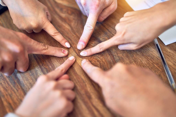 Grupo de trabajadores de negocios de pie con las manos juntas. Haciendo símbolo con los dedos en la oficina
 - Foto, imagen