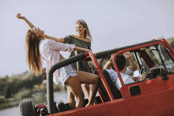 Grupo de jóvenes felices disfrutando de un viaje por carretera - Foto, imagen