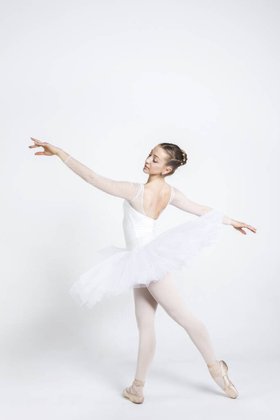 Young ballerina practising ballet moves in the studio - Foto, imagen