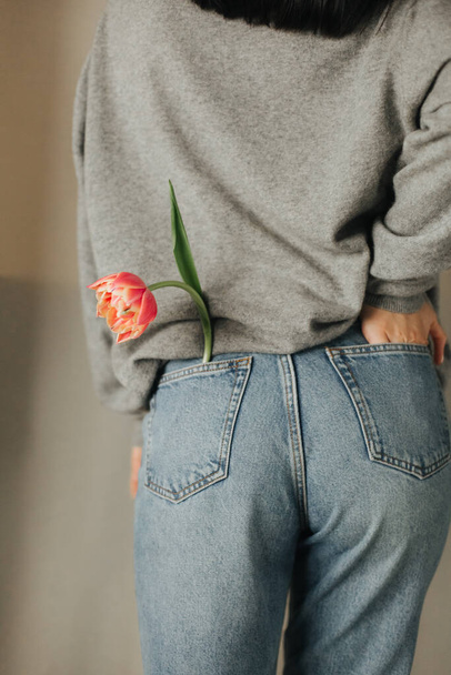 girl lifestyle holiday flower tulip jeans pocket backside sweater - Valokuva, kuva