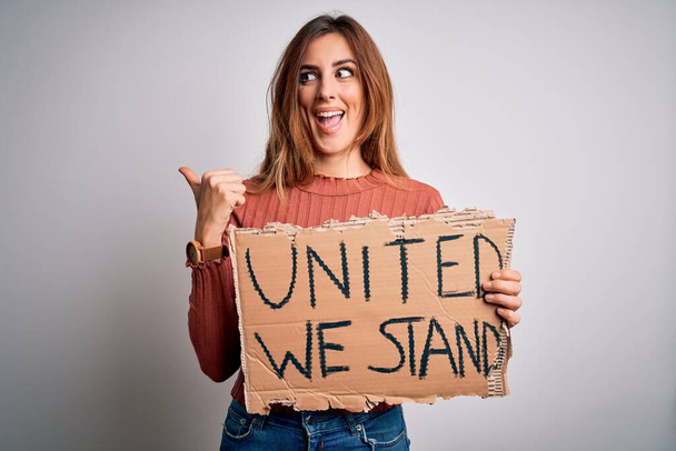 Молодая красивая брюнетка женщина с плакатом United мы стоим
 - Фото, изображение