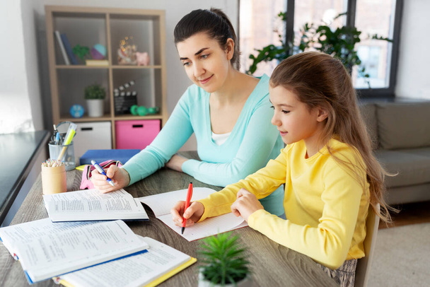 mother and daughter doing homework together - 写真・画像