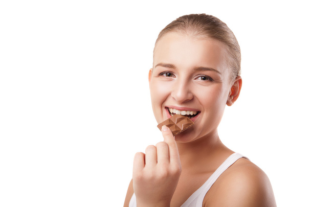 Blonde young woman biting chocolate isolated - Foto, Imagem