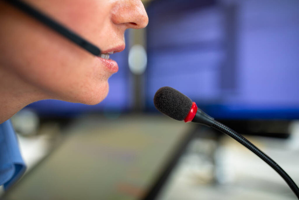 Funcionário do call center que se comunica por telefone usando um microfone externo para uma melhor sonoridade e ergonomia - Foto, Imagem