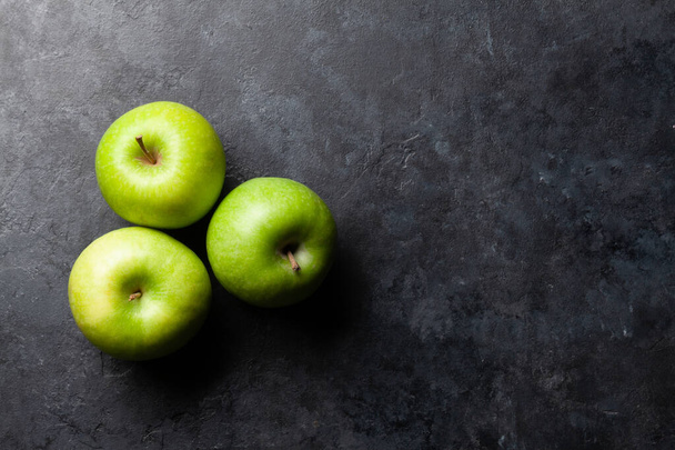 Reife grüne Apfelfrüchte auf dunklem Steintisch. Draufsicht mit Kopierraum. Flache Lage - Foto, Bild