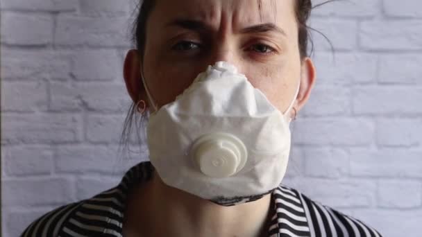 Jonge vrouw hoestend in een wit medisch masker kijkend naar de camera. Anderen beschermen tegen bacteriën en coronavirussen. De juiste voorzorgsmaatregelen voor epidemieën. Coronavirus griep infectie symptoom concept - Video