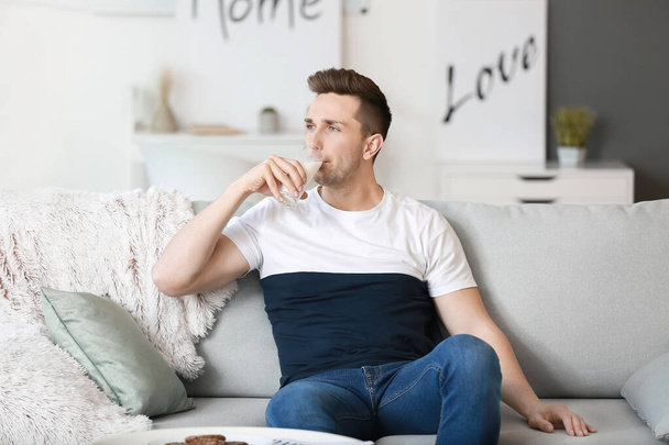 Young man drinking milk at home - Zdjęcie, obraz
