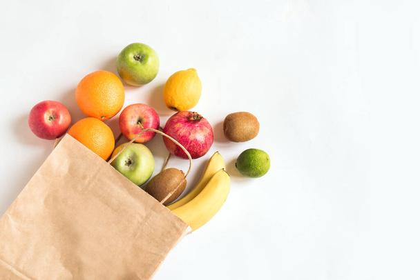 Delivery fruits, healthy food background. Vegan vegetarian food - organic fruits in paper bag on white, copy space, banner.Grocery shopping food supermarket and clean eating concept. - Foto, imagen