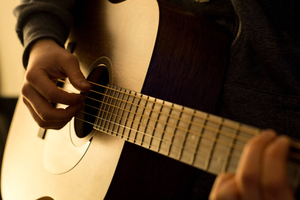暖かい光でギターを弾く男 - 写真・画像