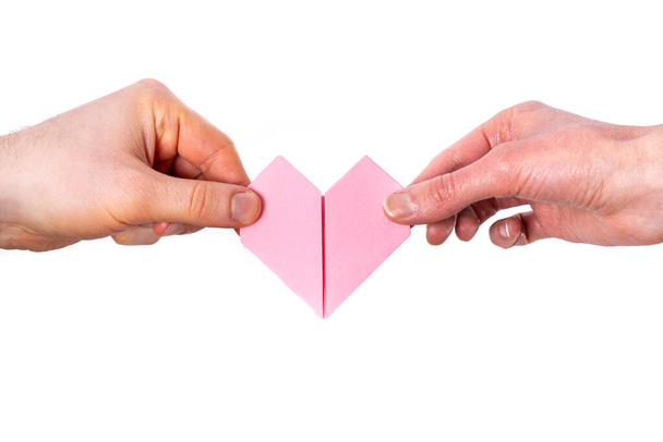 Man and Woman hold a heart made out of paper on a white background - Φωτογραφία, εικόνα