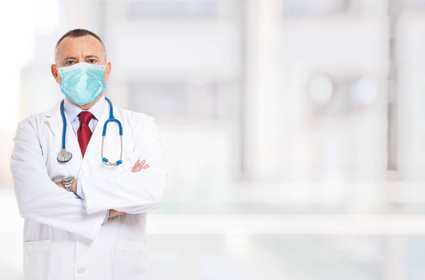 Portrait of a masked doctor in front of a bright background during coronavirus epidemic - Photo, image