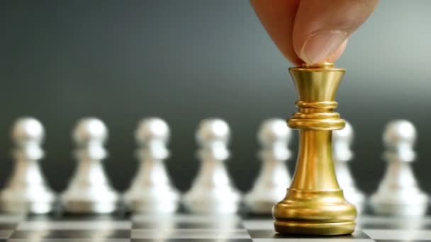 Золотий король шахової фігури стукає і перемагає над командою срібних пішаків на чорному тлі (Концепція стратегії компанії, перемоги бізнесу або рішення
) - Кадри, відео