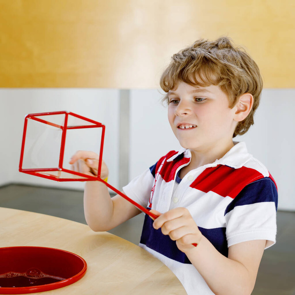 Щасливий хлопчик розважається з будівництвом і створює геометричні фігури, вивчає математику і геометрію
 - Фото, зображення