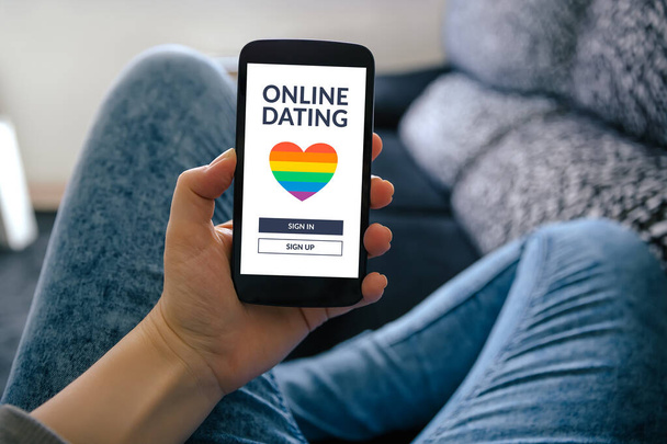 Ekranda LGBT uygulamalı akıllı telefon tutan bir kız. Gay çevrimiçi randevu. - Fotoğraf, Görsel
