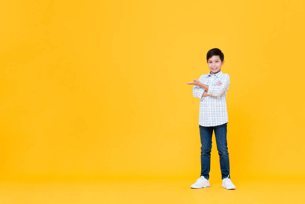 Retrato completo de un joven asiático sonriente haciendo un gesto cruzado de brazos con la palma abierta en un fondo amarillo aislado con espacio para copiar
 - Foto, imagen