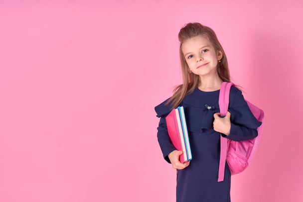 Back to school concept Half turned photo portrait of lovely confident beautiful clever girl with copybook notebook wearing school uniform dress pink bright backpack isolated - Фото, зображення