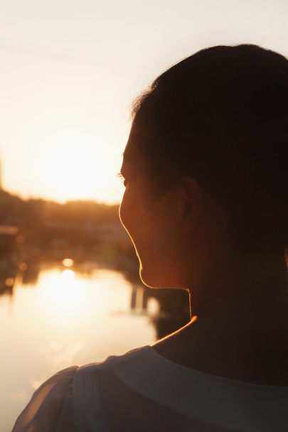 Silhouette des Gesichts einer Frau bei Sonnenuntergang - Foto, Bild