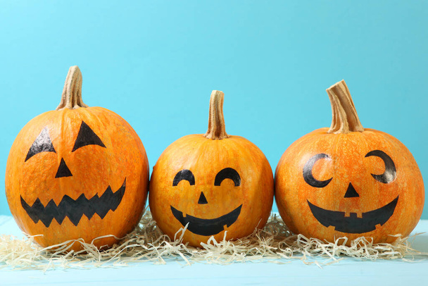 pumpkins with painted faces on a colored background for Halloween. - Photo, Image