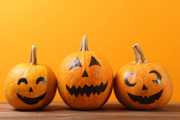 pumpkins with painted faces on a colored background for Halloween. - Foto, afbeelding