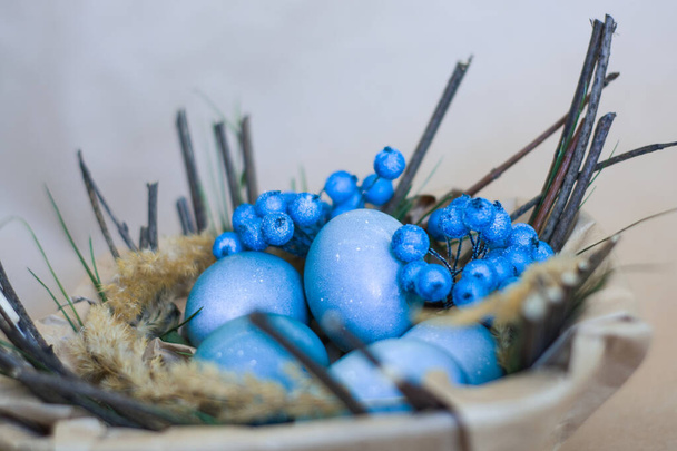 Velikonoční sváteční dekorace, zázemí. Košík s malovanými modrými vejci, s mřížemi, větvemi, květinami. Náboženská. - Fotografie, Obrázek