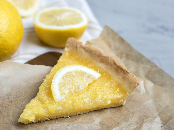 Pedazo de tarta de limón con rodaja de limones primer plano sobre fondo de piedra, espacio de copia
 - Foto, Imagen